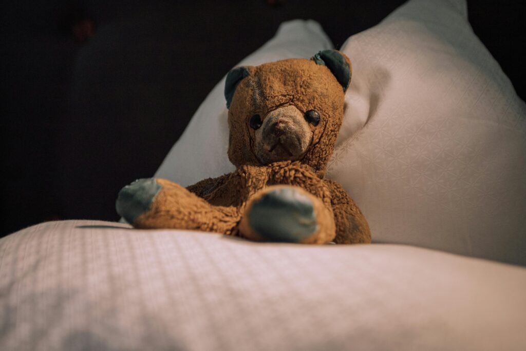 A charming vintage teddy bear rests on a pillow, exuding warmth and nostalgia.