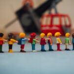 Miniature plastic figures lined up in front of a toy helicopter, creating a playful scene.