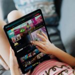 A child using a tablet for streaming cartoons, relaxing on a couch indoors.